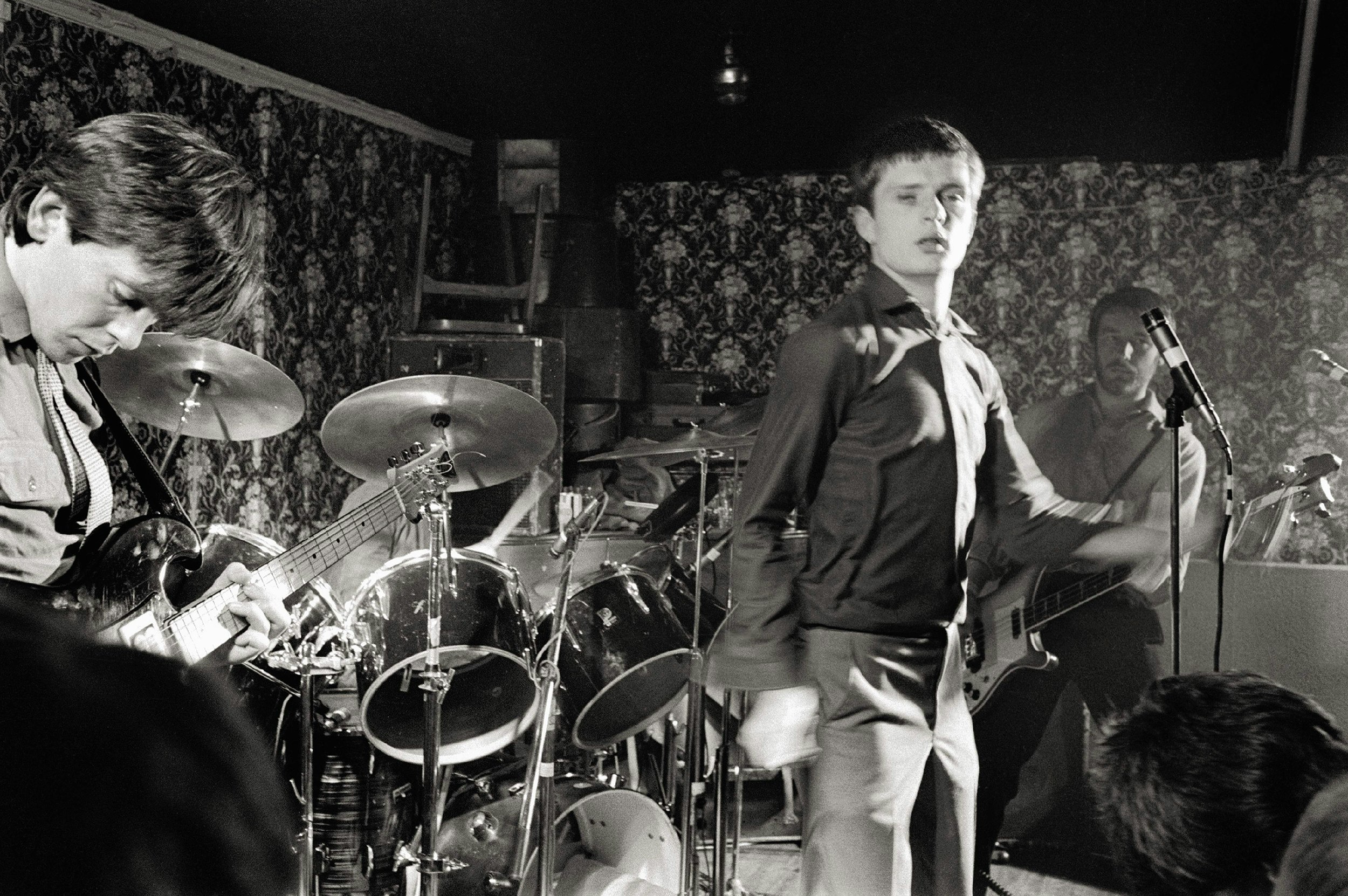 Joy Division’s guitarist Bernard Sumner, singer Ian Curtis, and bassist Peter Hook at Bowdon Vale Youth Club, circa 1979. Photo by Martin O’Neill/Redferns.